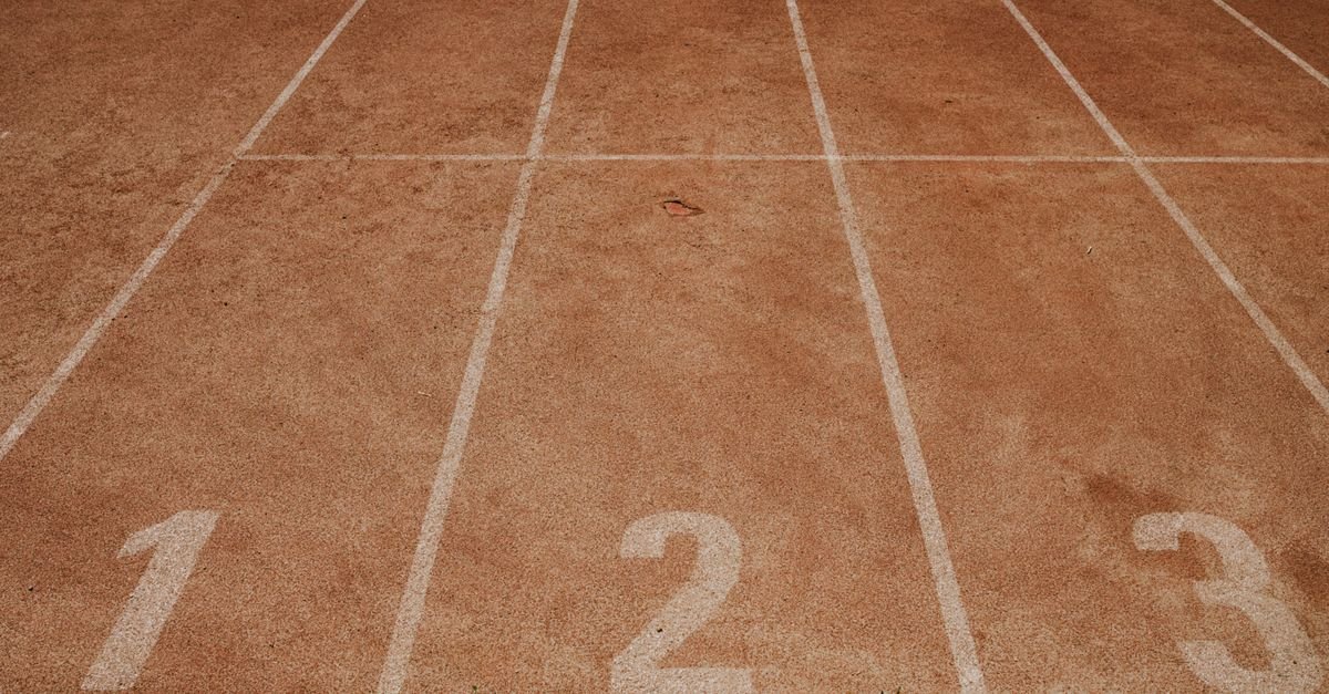 Pista de atletismo com raias numeradas 1, 2 e 3 pintadas em branco