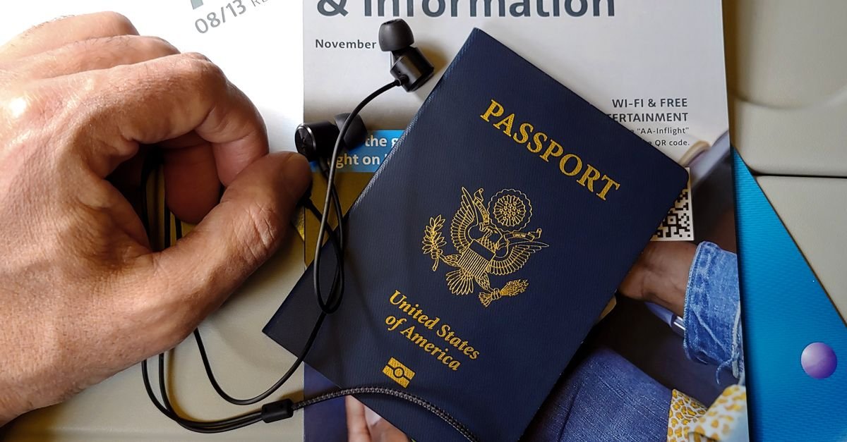 Passaporte dos Estados Unidos apoiado sobre revista de bordo em assento de aviao
