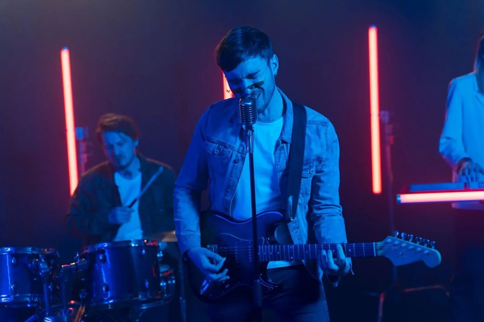Banda tocando em palco com iluminação azul