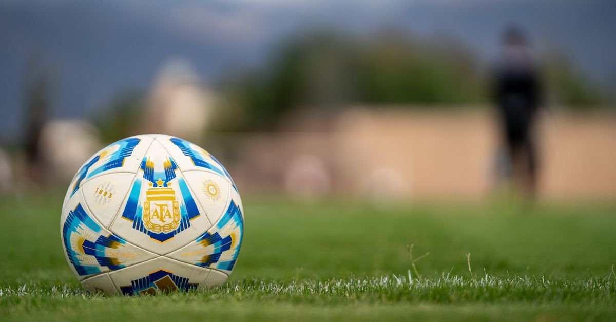 Bola de futebol com o escudo da AFA sobre um campo gramado