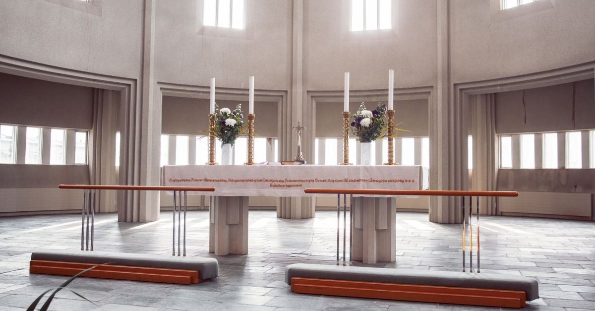 Altar de igreja com velas e flores sob luz natural, imagem ilustrativa