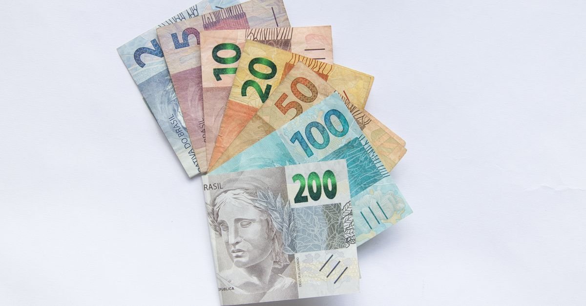 Leque de cédulas de real de vários valores sobre fundo branco