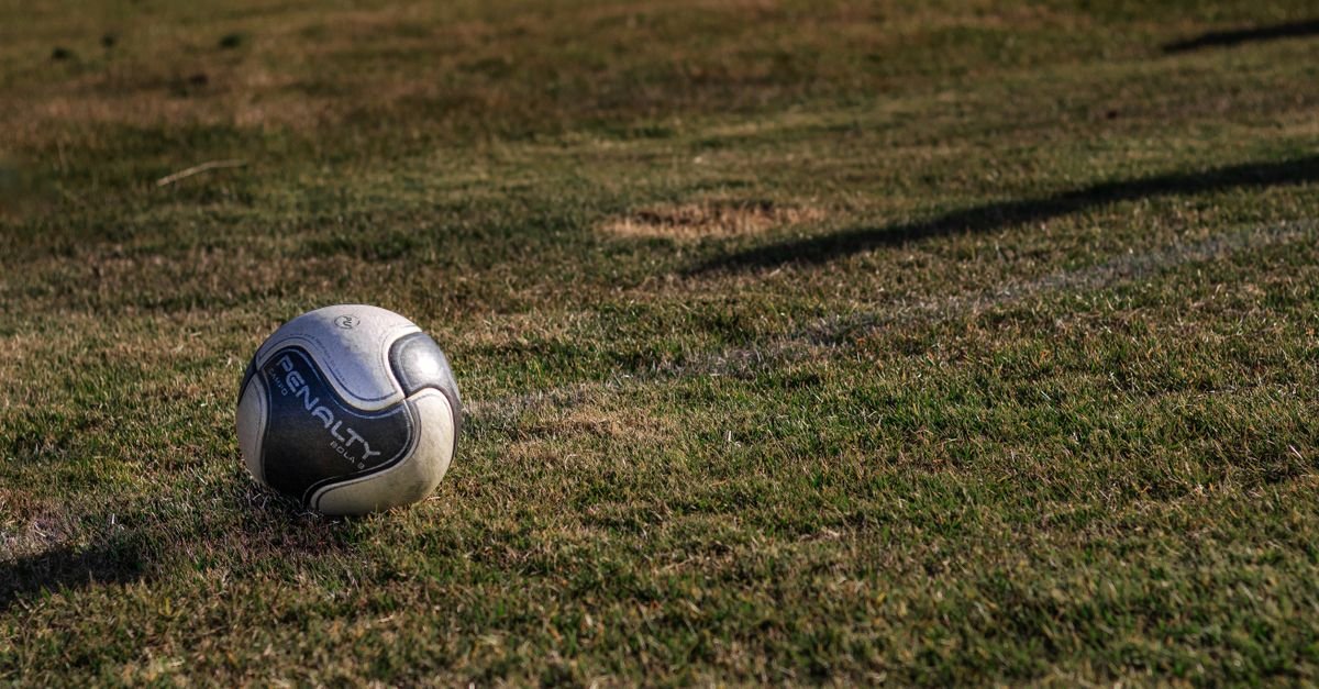 Bola de futebol sobre o gramado de um campo de jogo