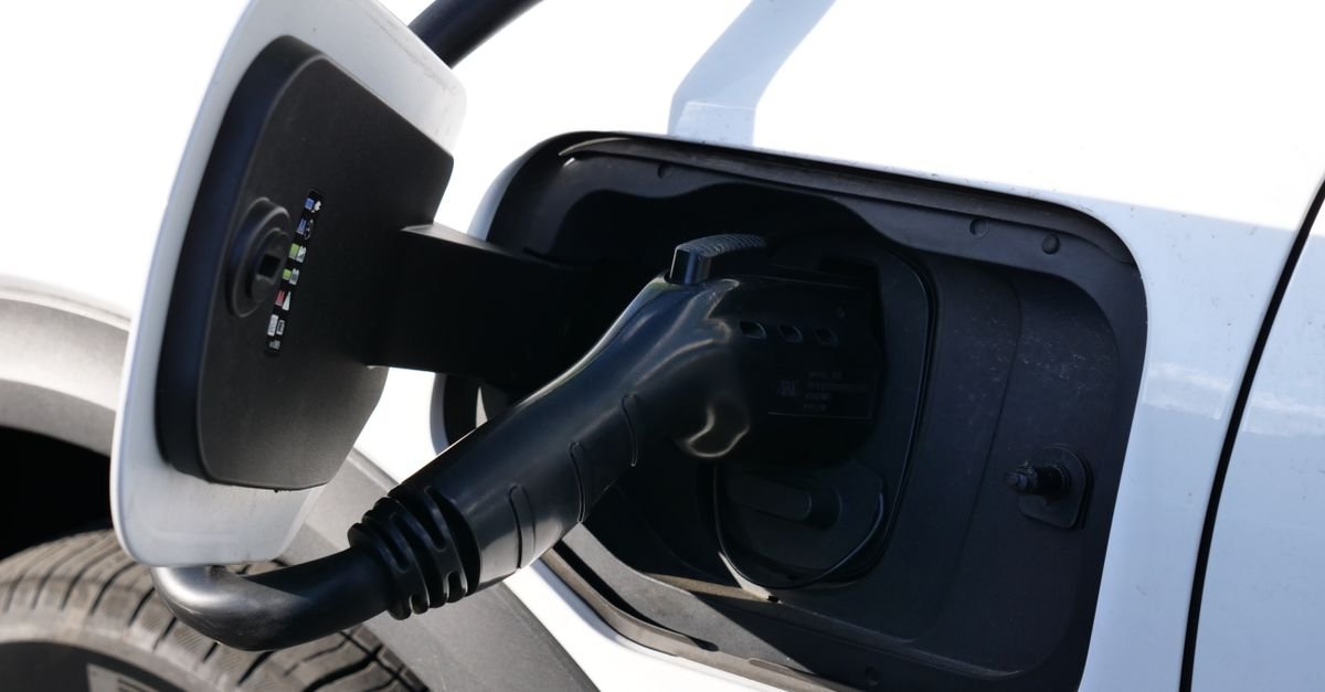 Plugue de recarga conectado a carro elétrico em ponto de carregamento
