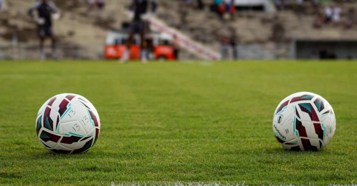 Duas bolas de futebol no gramado de um estádio antes de partida