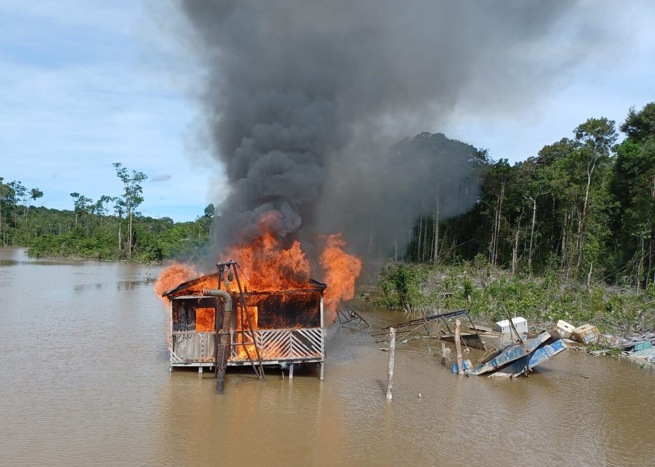 Imagem ilustrativa de draga de garimpo ilegal em chamas sobre rio na Amazônia