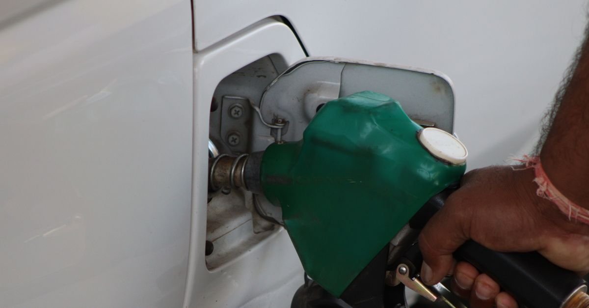 Bico de abastecimento verde inserido no tanque de um carro em posto de combustível