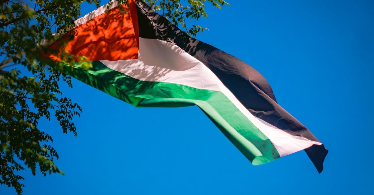 Bandeira palestina tremulando contra o céu azul