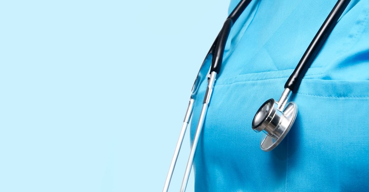Estetoscópio pendurado no jaleco azul de profissional de saúde