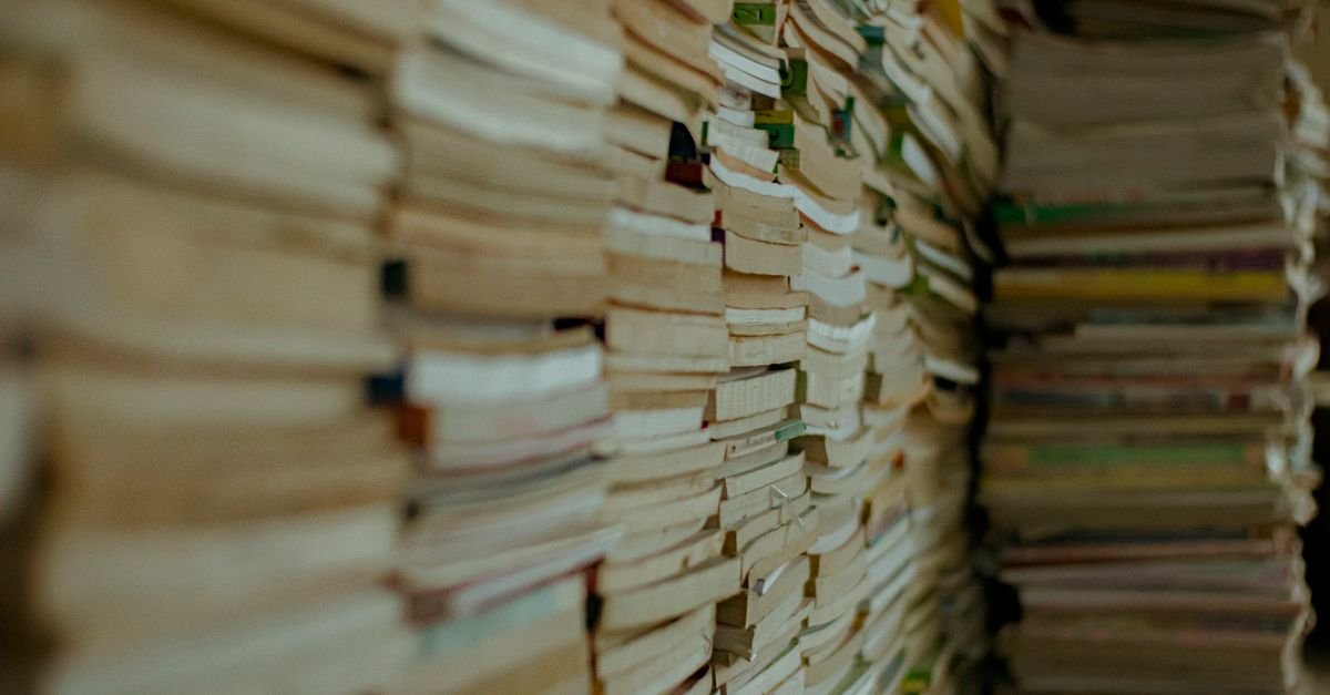 Pilhas de livros usados empilhados lado a lado formando uma parede de páginas