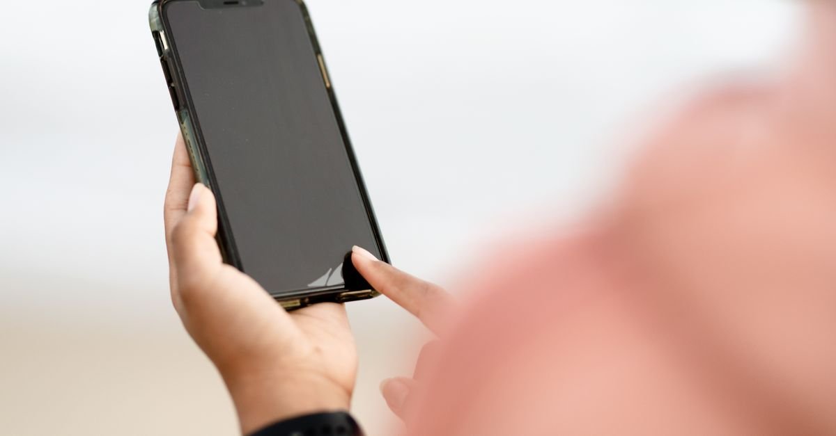 Mão tocando a tela de um celular