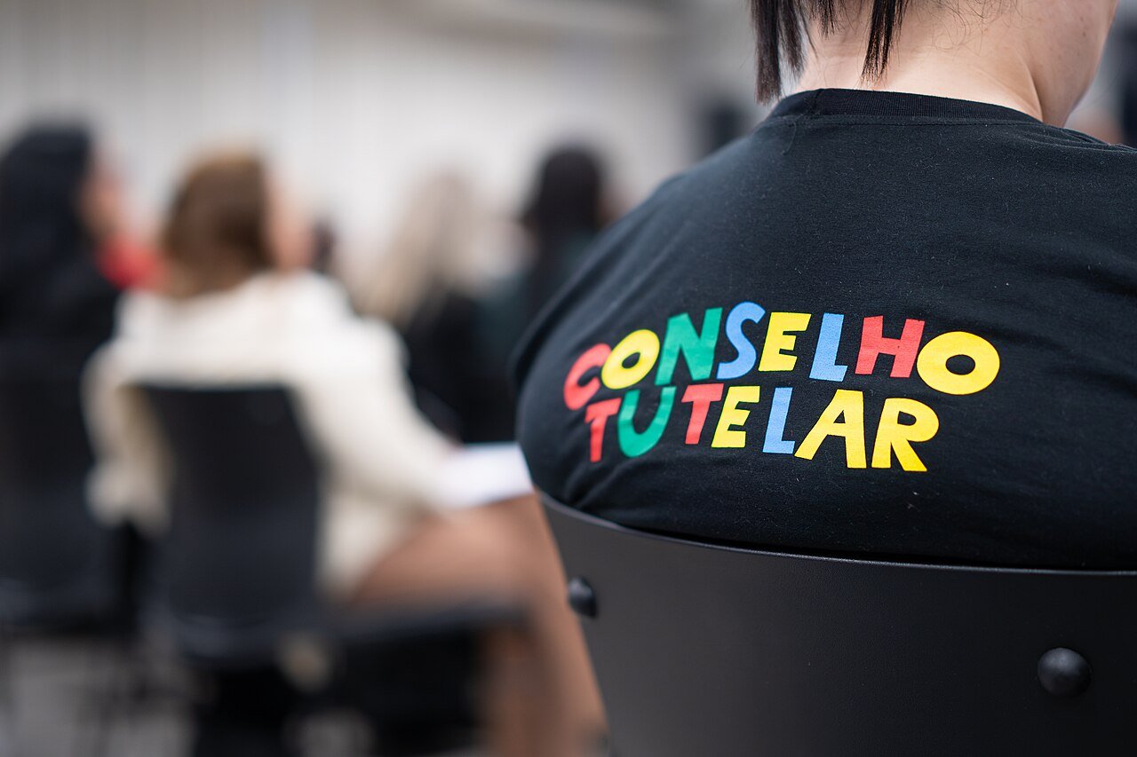 Pessoa de costas com camiseta escrita Conselho Tutelar durante audiência pública