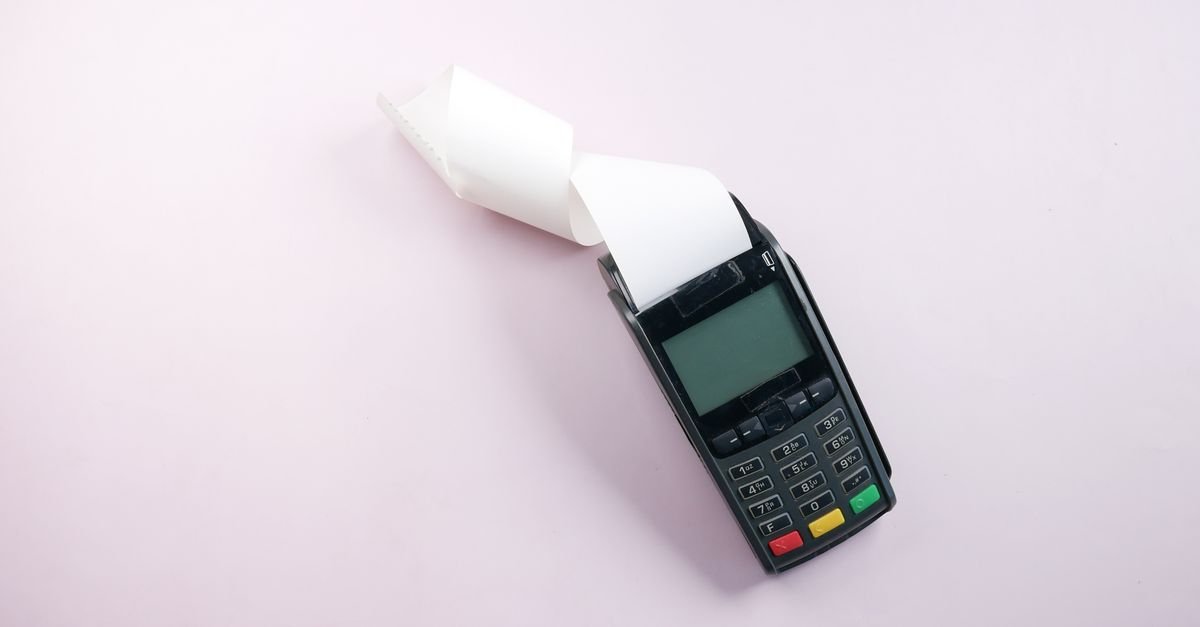 Maquininha de cartão com bobina de papel sobre superfície clara