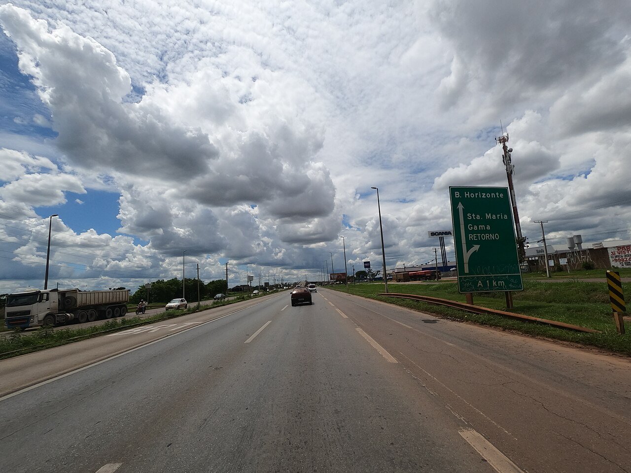Pista da BR-040 no DF com placa indicando Belo Horizonte, Santa Maria e Gama e a via marginal à esquerda