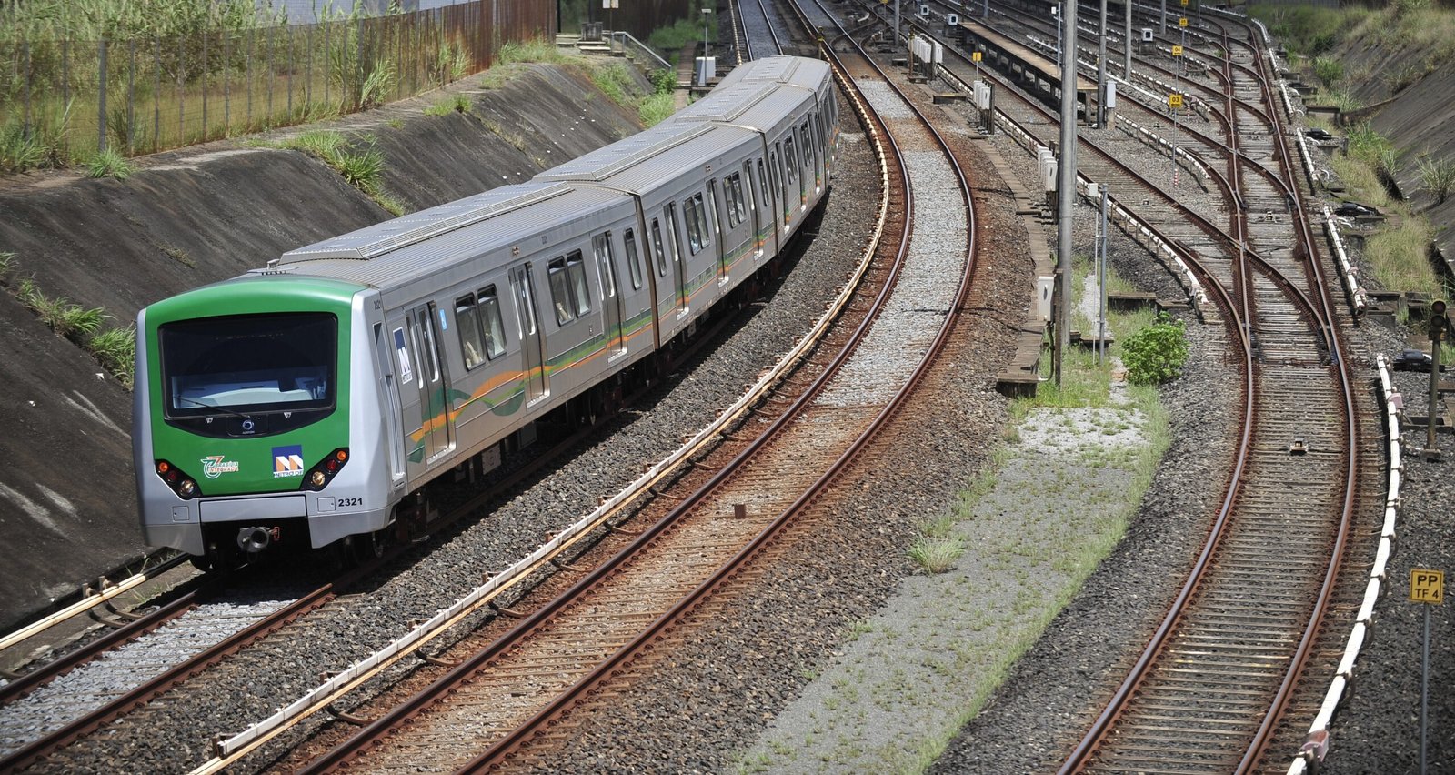 Trem do Metrô-DF em trecho de superfície da Linha 1, com o pátio de manobras ao fundo