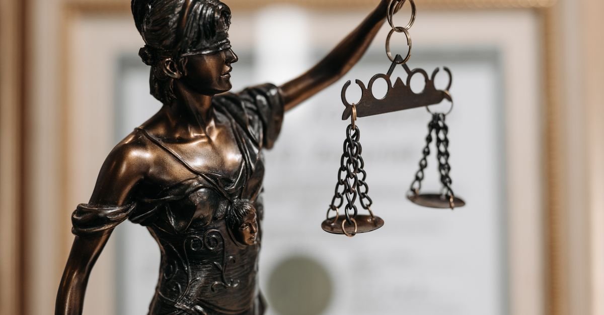 Estátua da Justiça em bronze segura balança em close