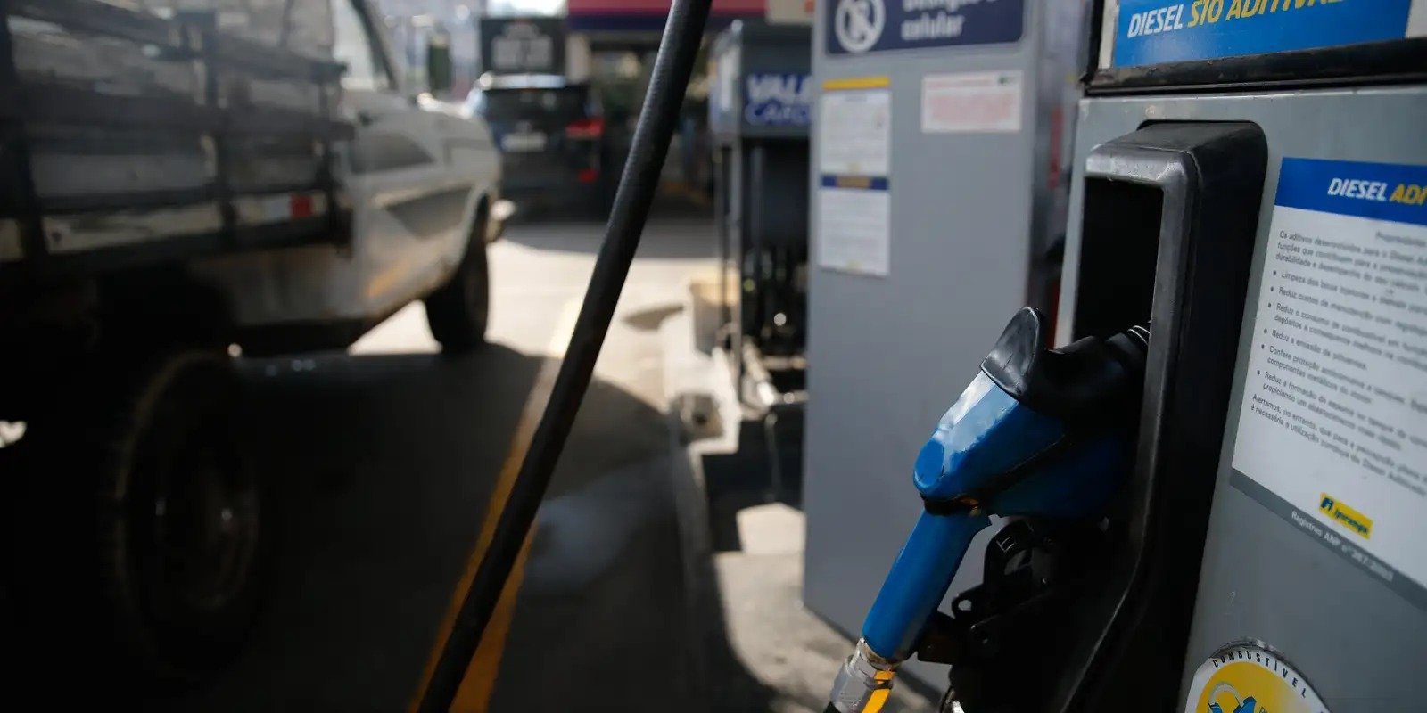 Bico de bomba de diesel S10 aditivado em posto de combustivel brasileiro, com caminhonete ao fundo