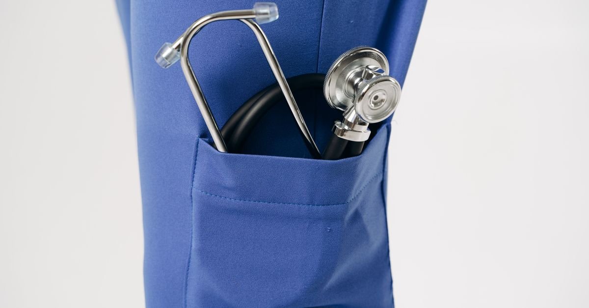 Estetoscópio no bolso de um uniforme azul de profissional de saúde