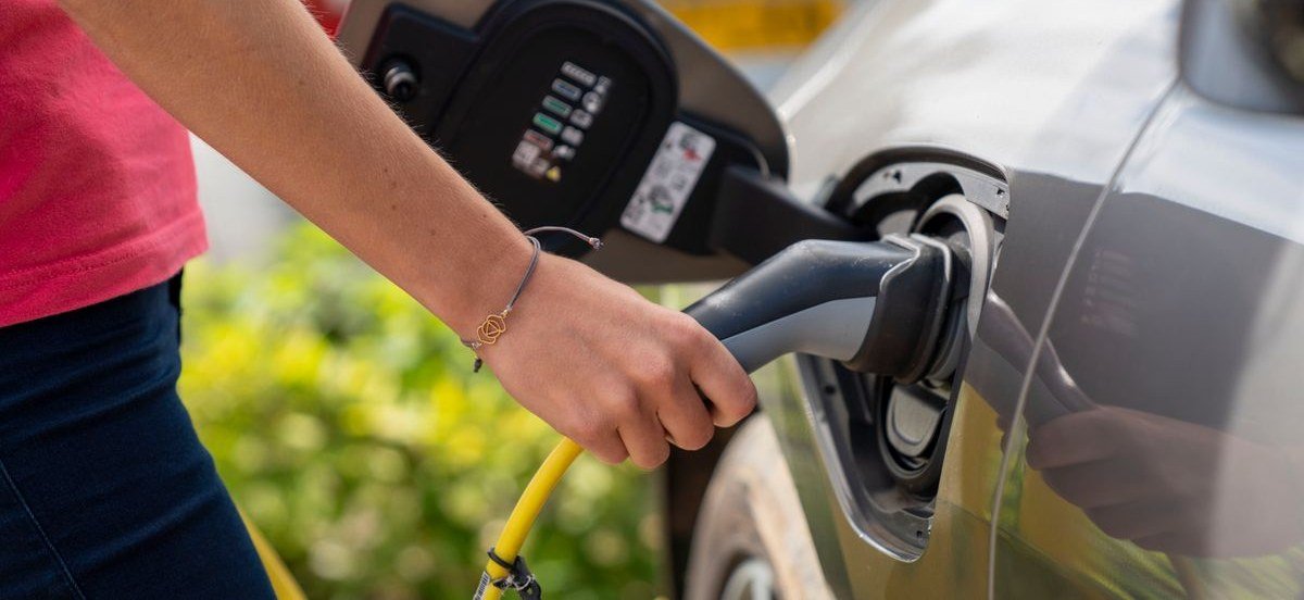 Cabo de recarga sendo conectado à tomada de um veículo elétrico