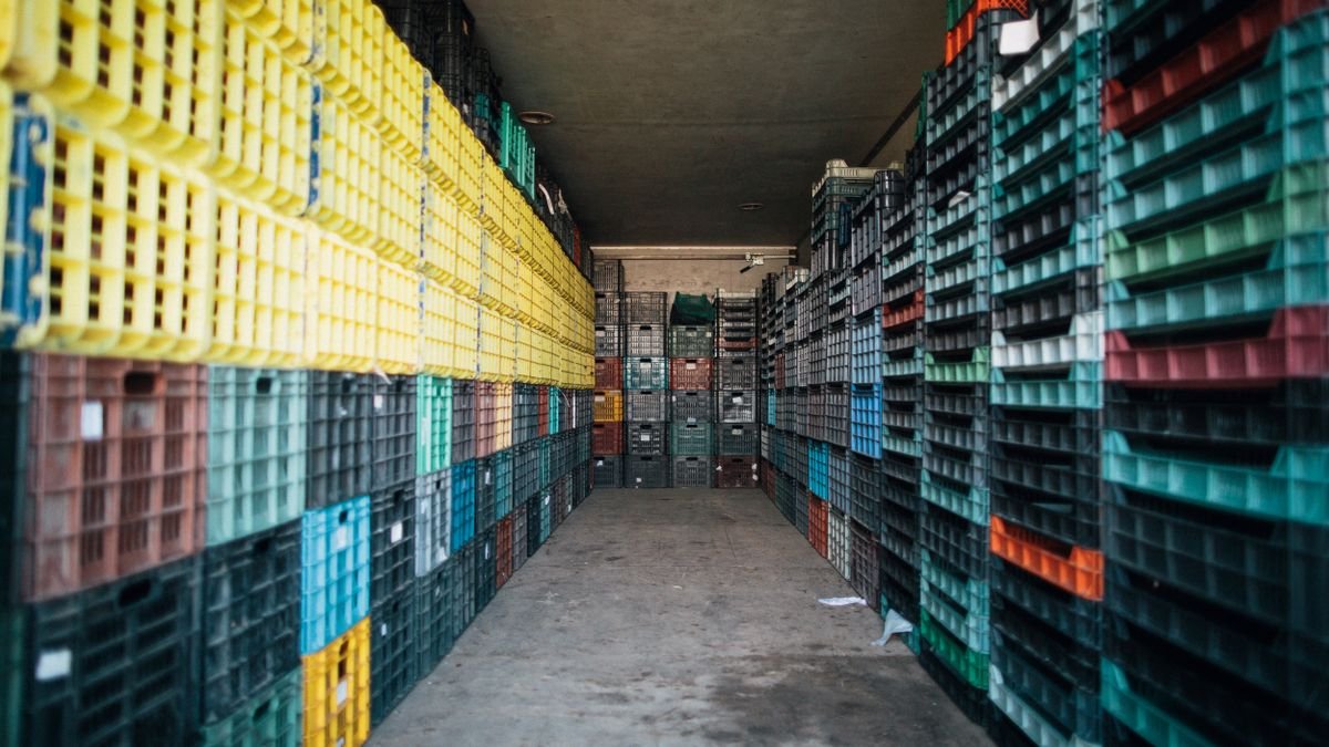 Corredor de depósito com engradados plásticos empilhados