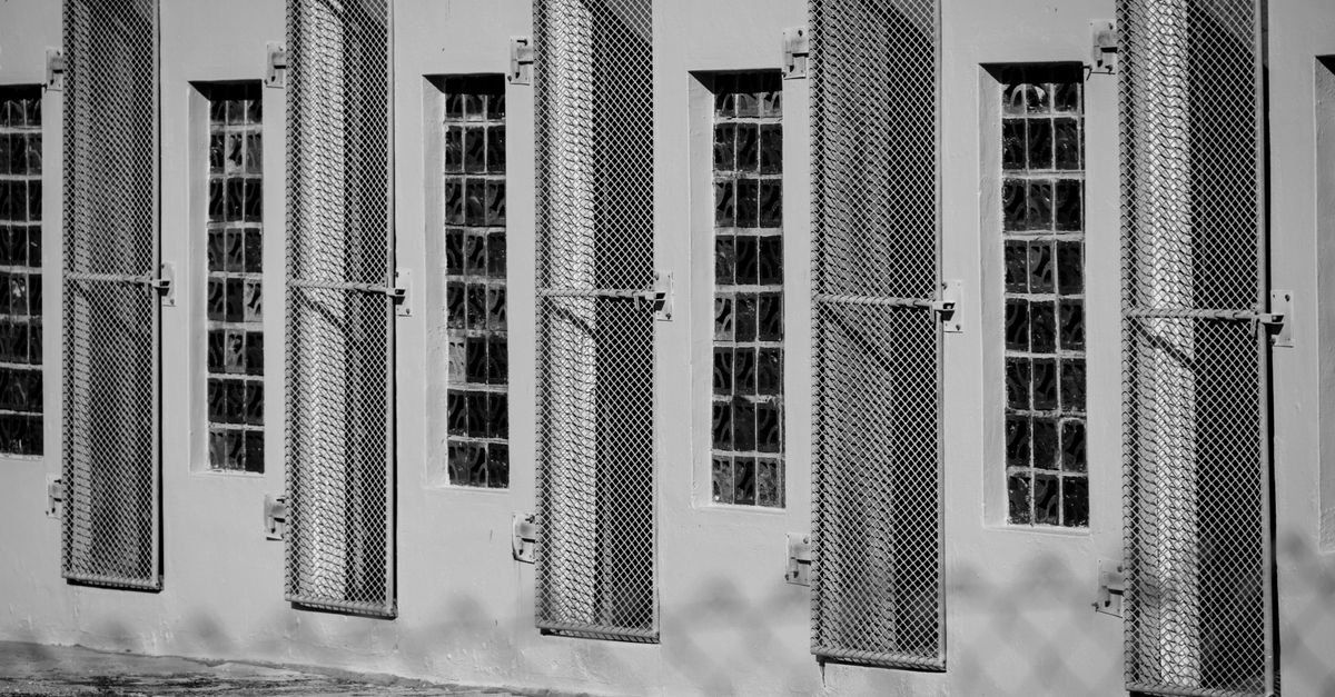Janelas com grades metálicas em fachada, em foto monocromática