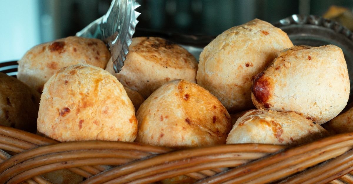 Pães de queijo recém-assados em cesta de vime