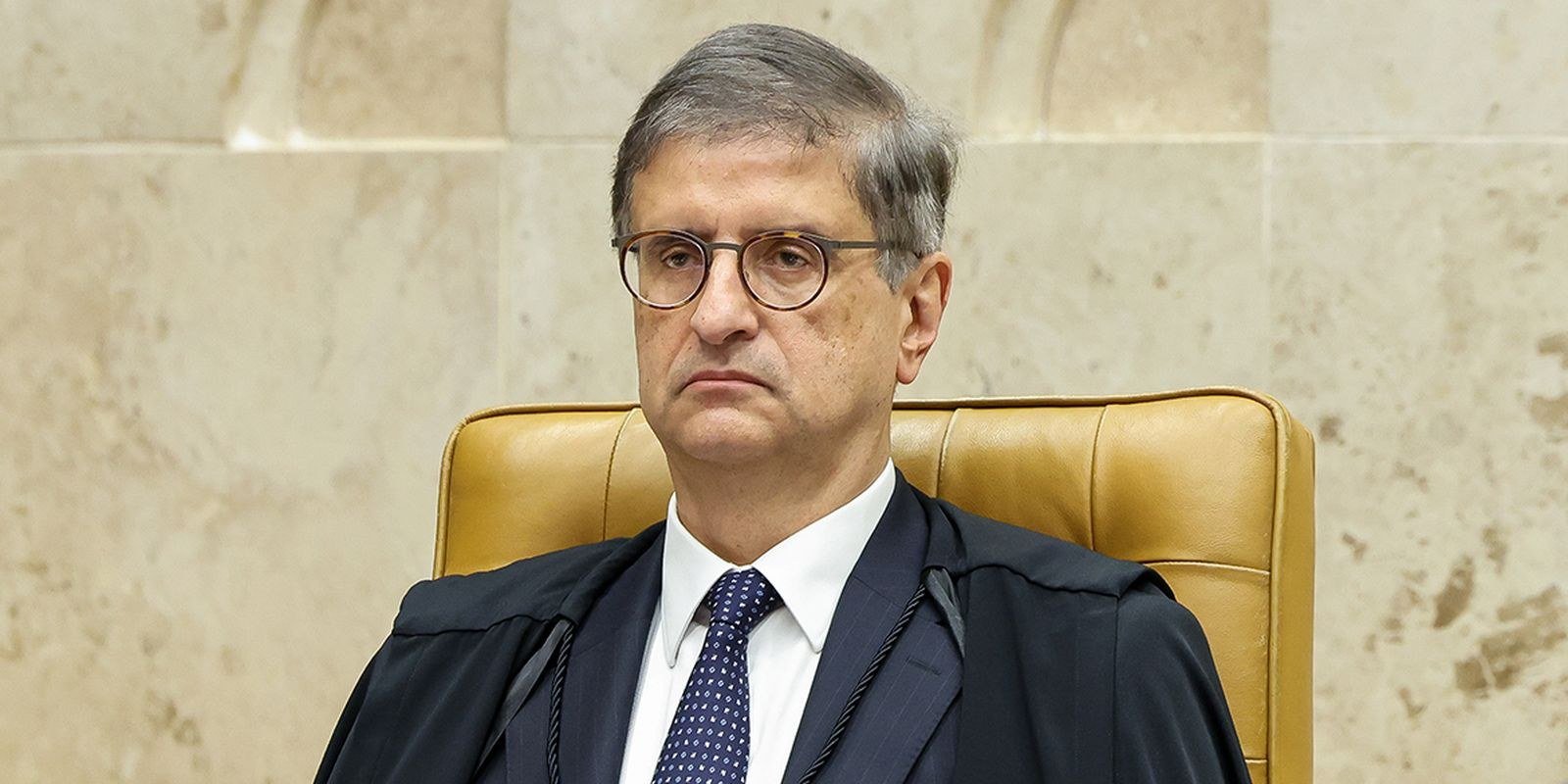 O procurador-geral da República, Paulo Gonet, sentado na cadeira do plenário do STF, de toga e gravata azul