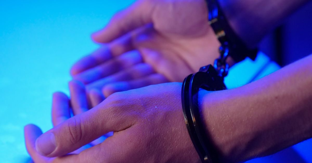 Mãos de uma pessoa algemada durante abordagem policial