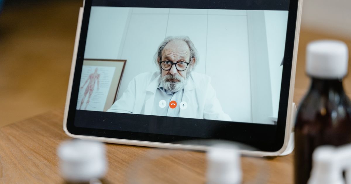 Médico em videochamada na tela de um tablet durante consulta remota