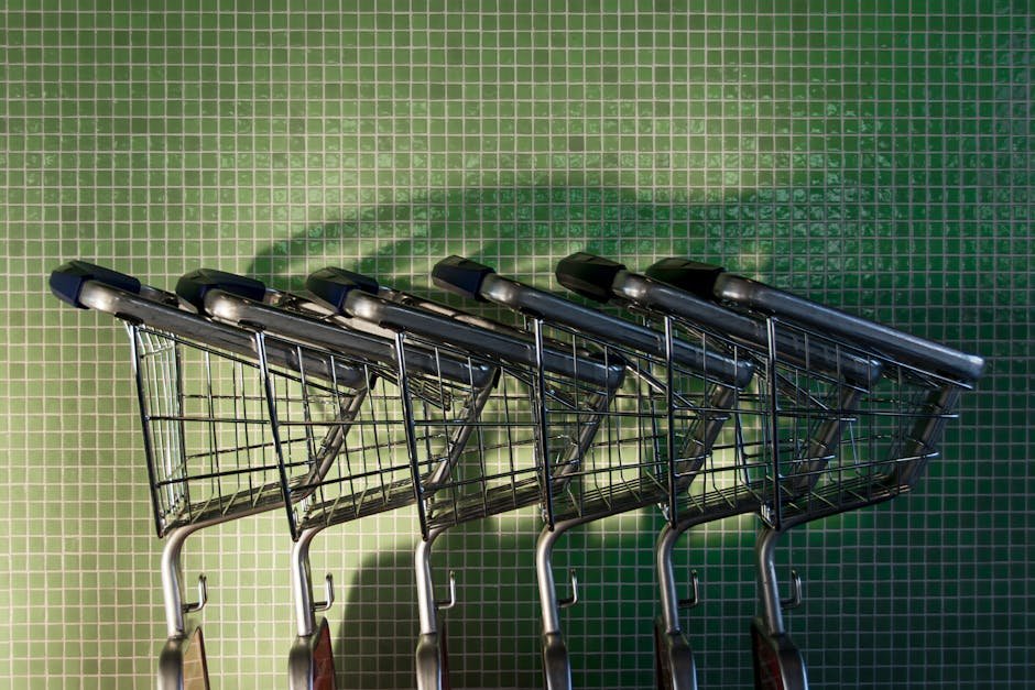 Carrinhos de compras em fila contra parede com azulejos