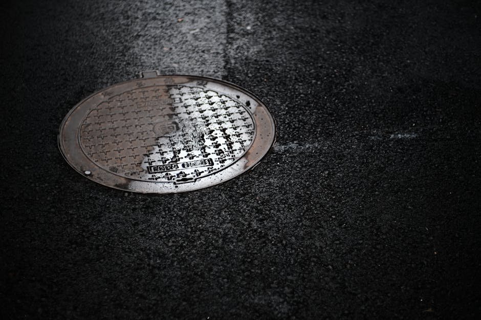 Bueiro urbano em rua pavimentada apos chuva