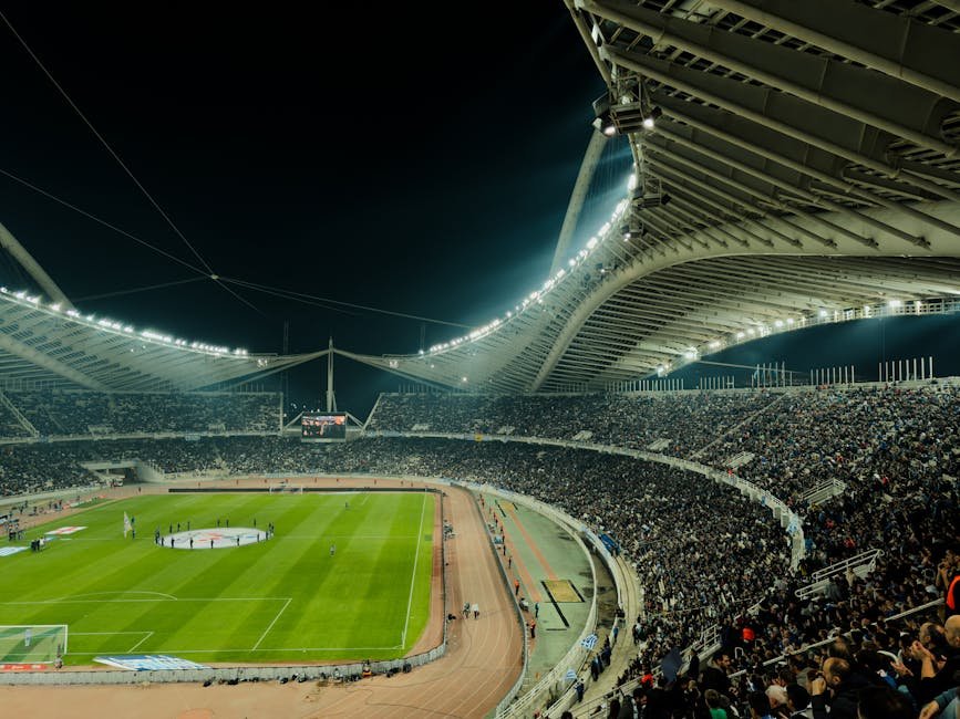 Estádio de futebol iluminado durante partida noturna