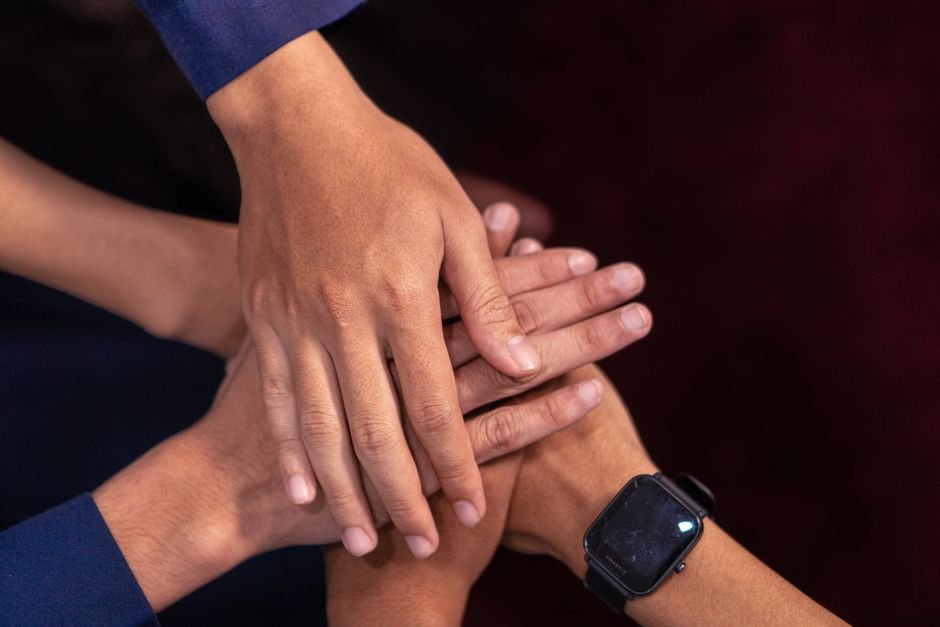 Maos diversas unidas em sinal de cooperacao