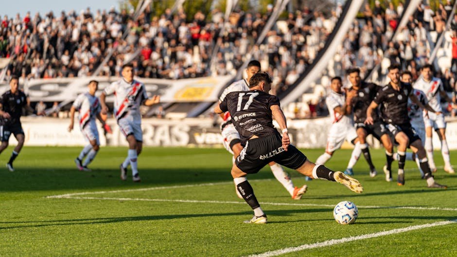 Jogador de futebol em acao durante partida em estadio