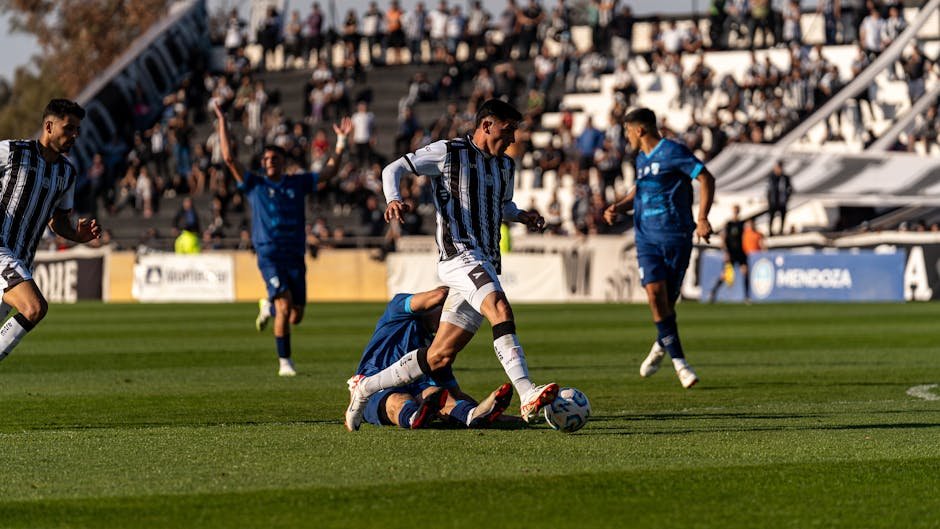 Jogadores de futebol disputando lance em estadio