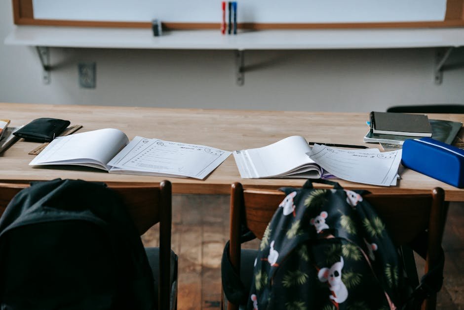 Mesa de escola com cadernos abertos e material escolar