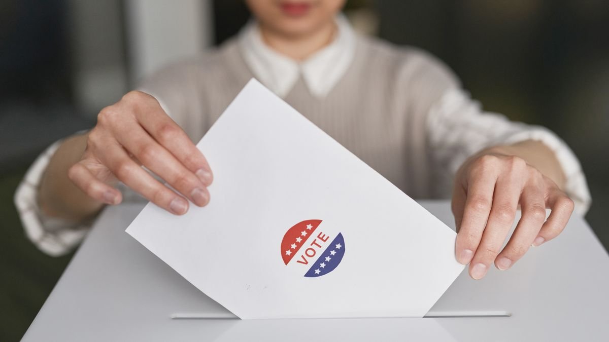 Pessoa depositando voto em urna; imagem ilustrativa sobre título de eleitor