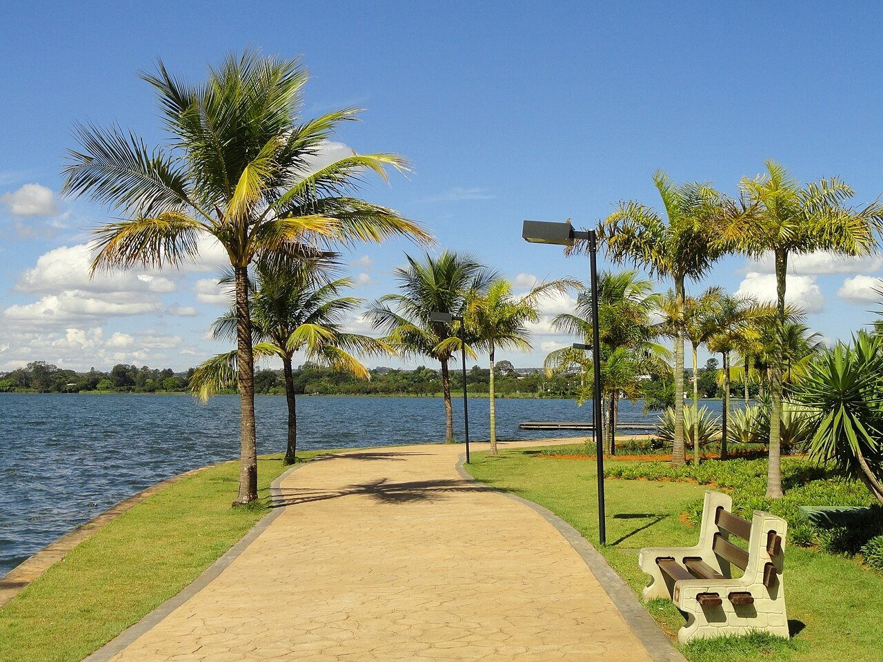 Calçada à beira do Lago Paranoá no Pontão do Lago Sul, com coqueiros e banco