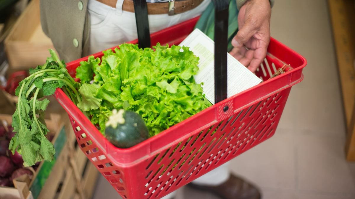 Cesta de compras com verduras em mercado