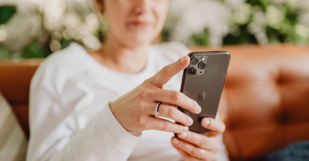 Mulher usa o smartphone para acessar informação de forma discreta
