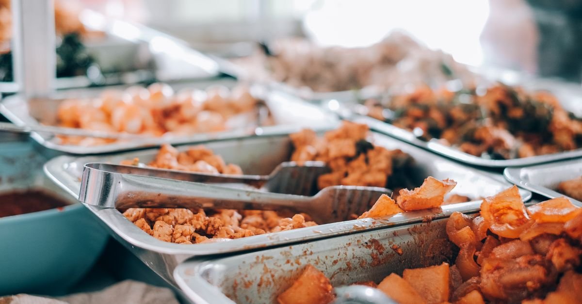 Bandejas de inox com refeições em balcão de self-service