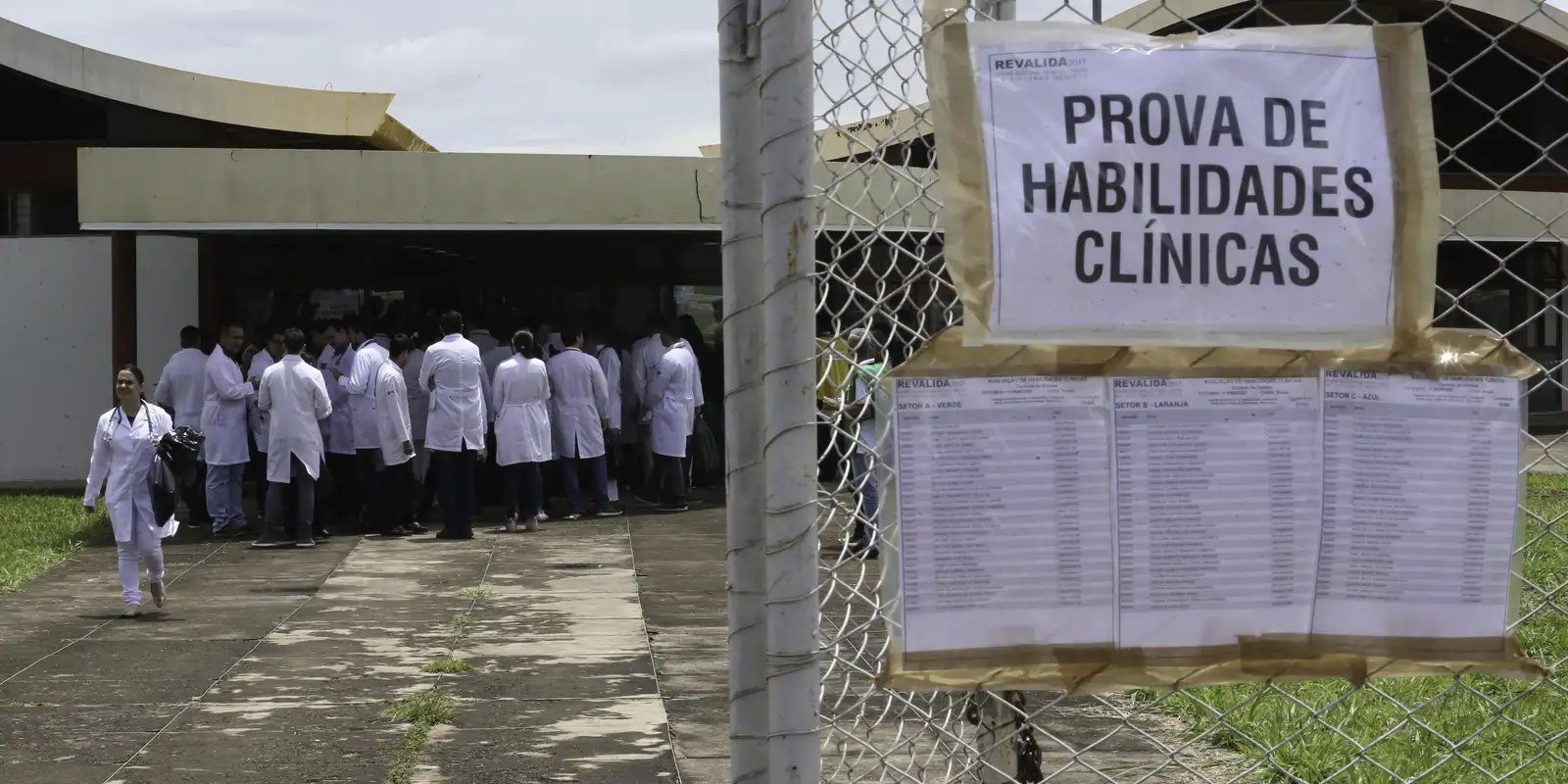 Cartaz com os dizeres Prova de Habilidades Clínicas em grade, com candidatos de jaleco branco ao fundo