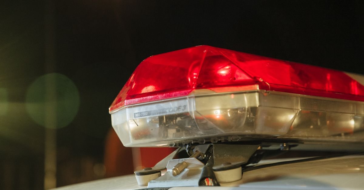 Giroflex vermelho aceso no teto de uma viatura policial durante a noite