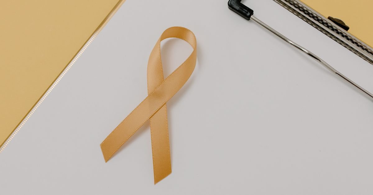 Laço dourado, símbolo da campanha de conscientização sobre o câncer infantojuvenil, sobre uma prancheta