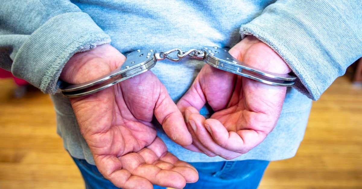 Homem algemado com as mãos às costas