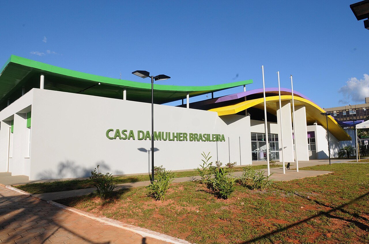 Fachada da Casa da Mulher Brasileira, prédio branco com cobertura curva colorida, em Brasília