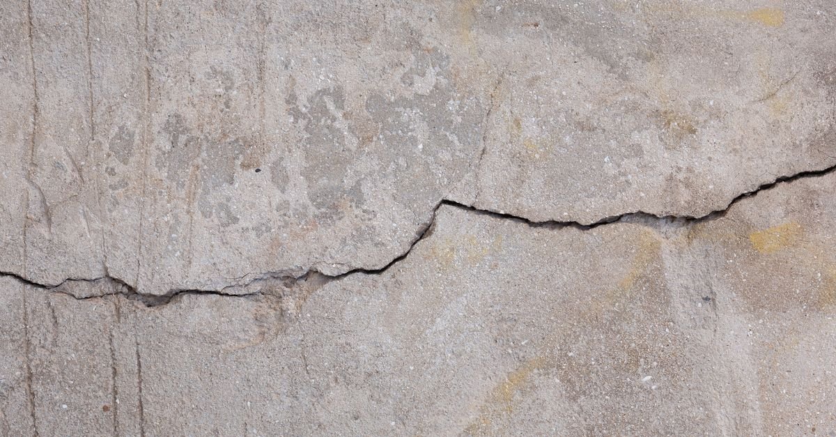 Parede de concreto com rachadura profunda atravessando a superfície