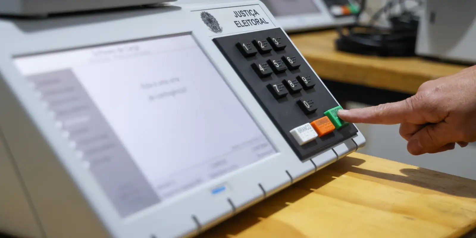 Eleitor digita voto no teclado de urna eletronica da Justica Eleitoral brasileira