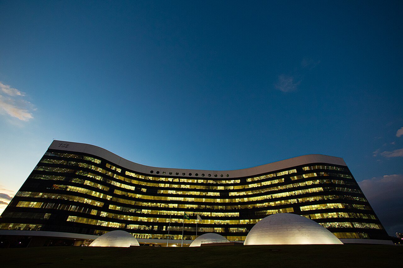 Fachada iluminada do edifício-sede do Tribunal Superior Eleitoral, em Brasília, no fim da tarde