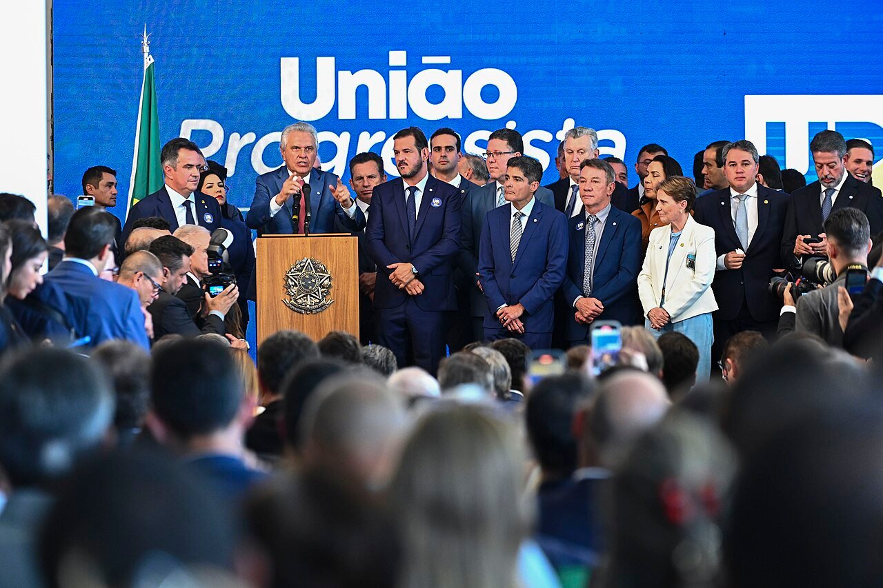 Lideranças da federação União Progressista em ato de lançamento, com painel do partido ao fundo